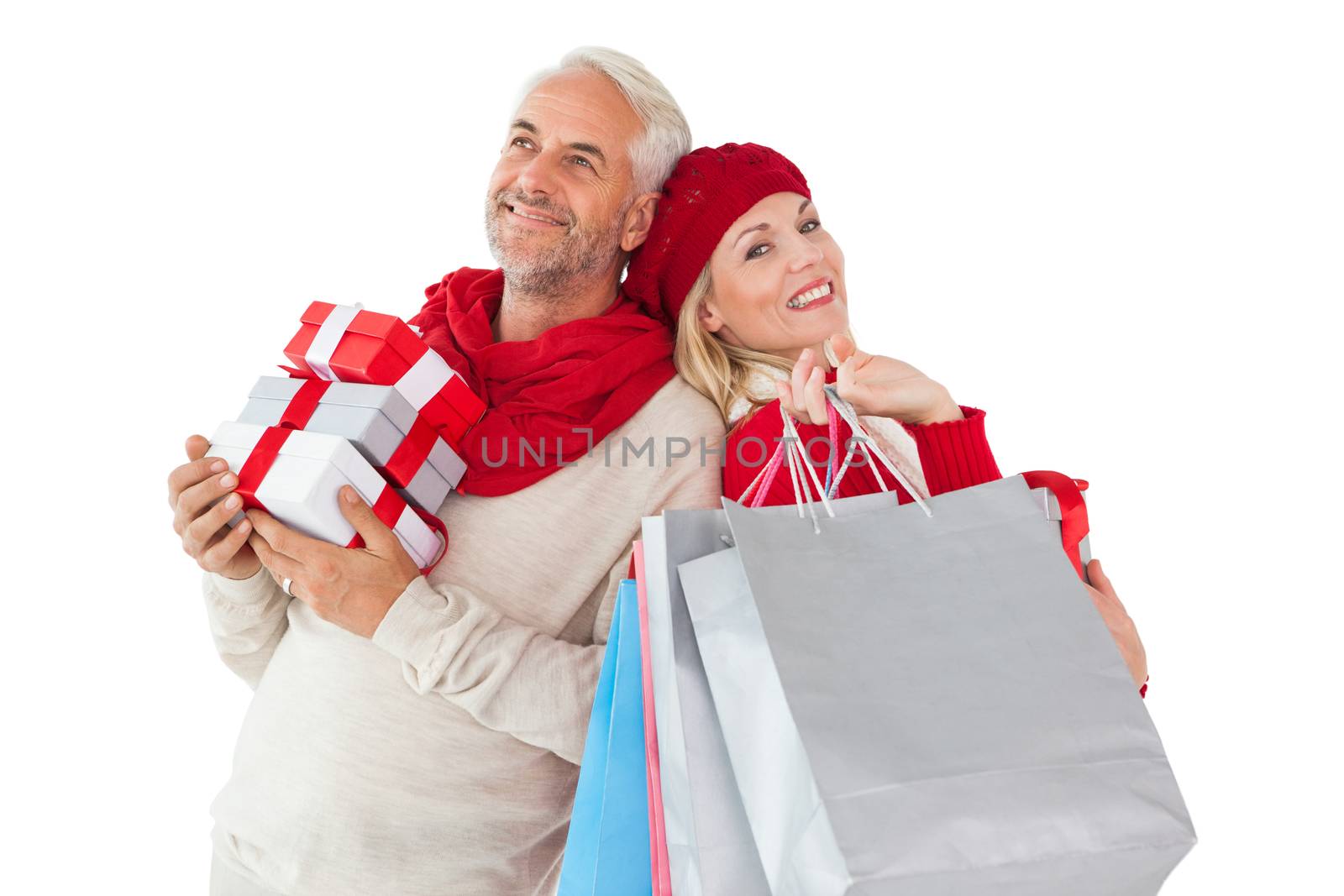 Smiling couple in winter fashion holding presents and shopping bags on white background