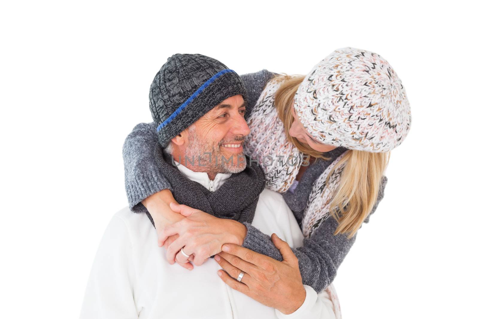 Happy couple in winter fashion embracing on white background