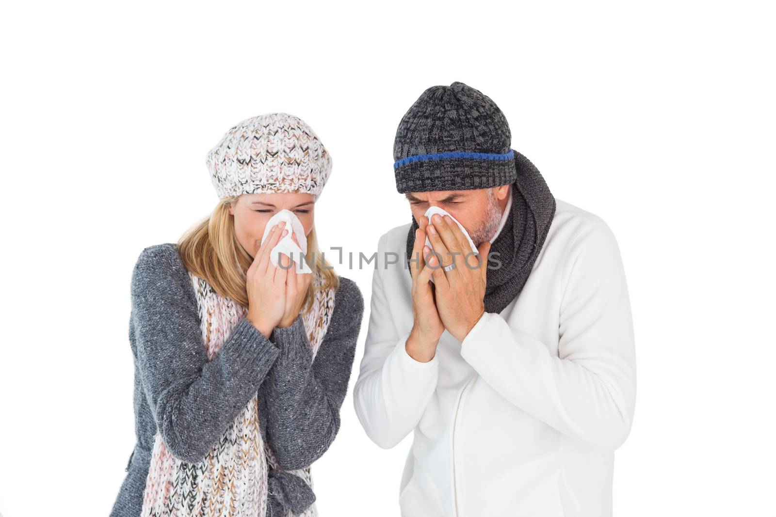 Sick couple in winter fashion sneezing by Wavebreakmedia