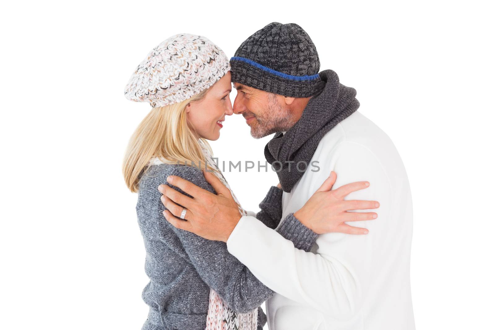 Happy couple in winter fashion embracing on white background