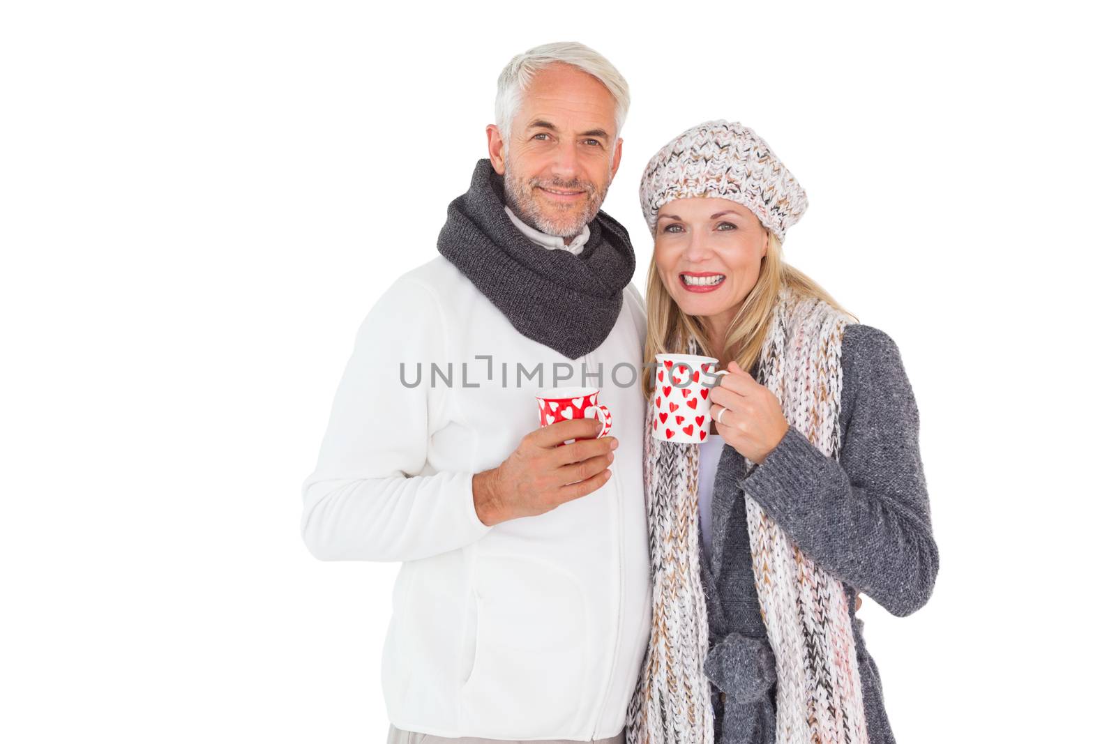 Happy couple in winter fashion holding mugs on white background