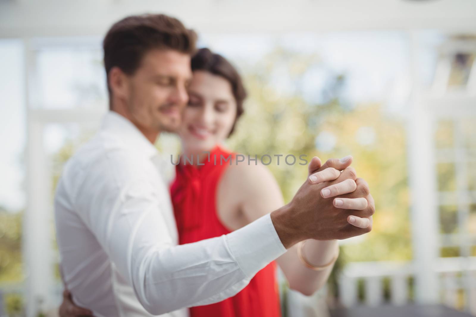 Romantic couple dancing with hand in hand in restaurant