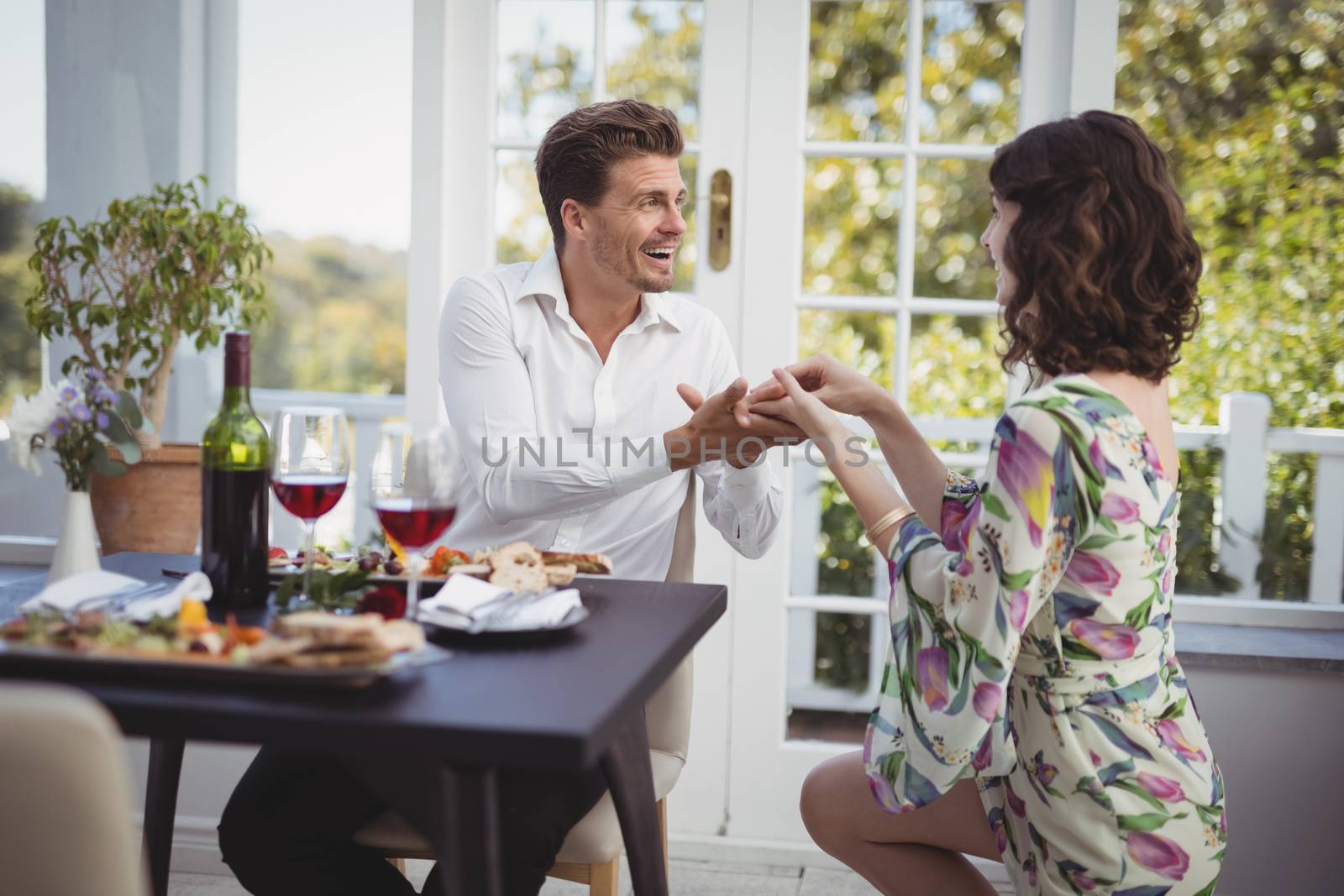 Romantic couple holding hands while having meal by Wavebreakmedia