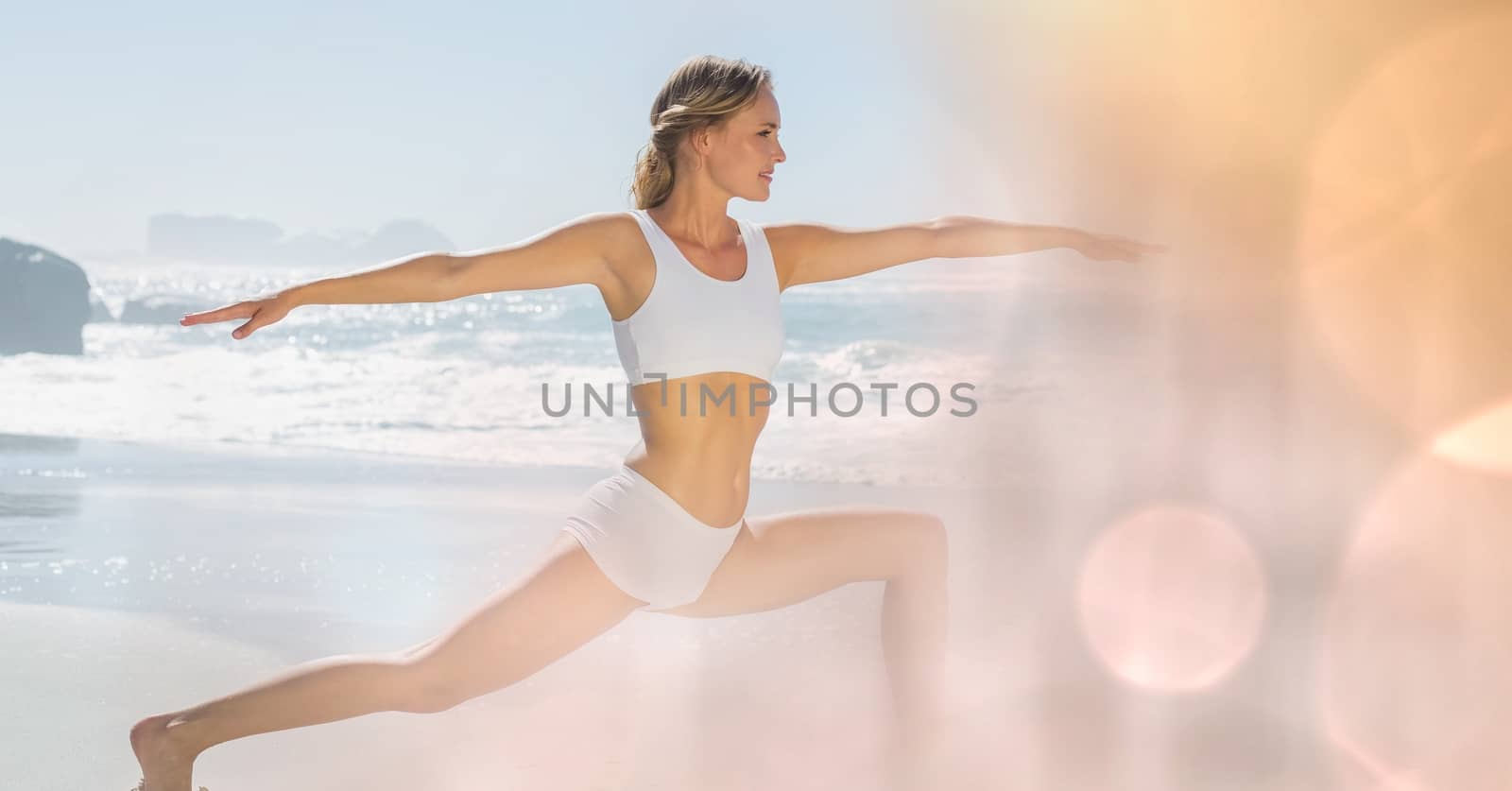 Fit young woman practicing yoga at beach by Wavebreakmedia
