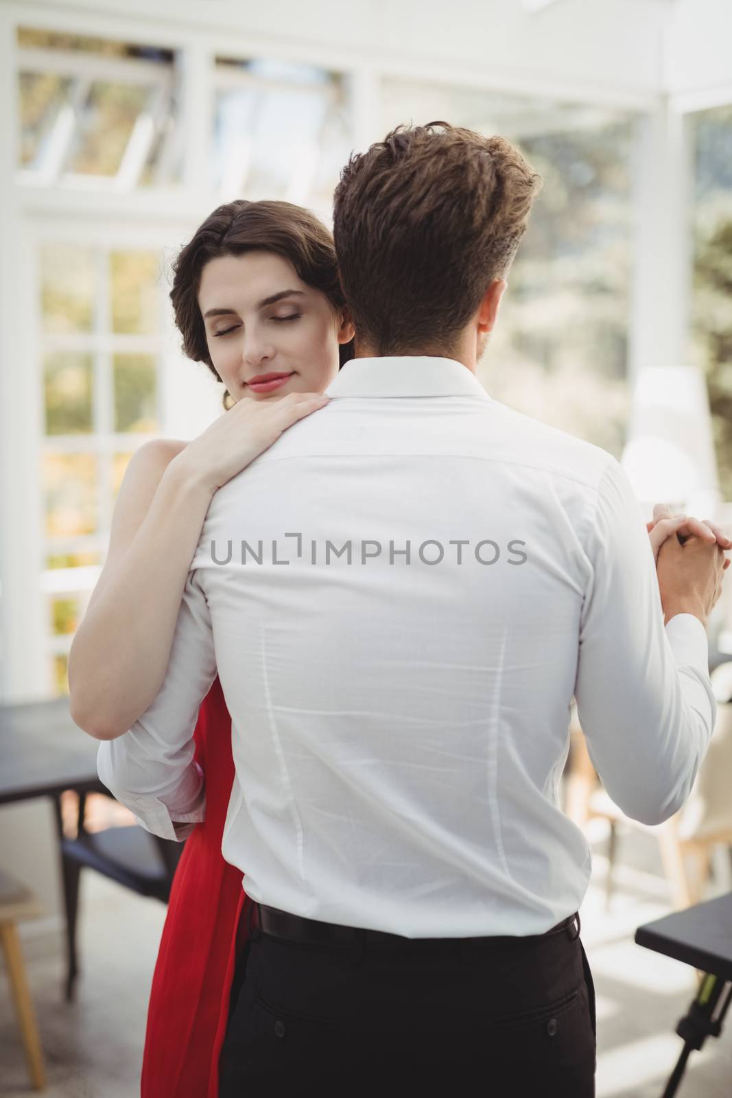 Romantic couple dancing with hand in hand in restaurant