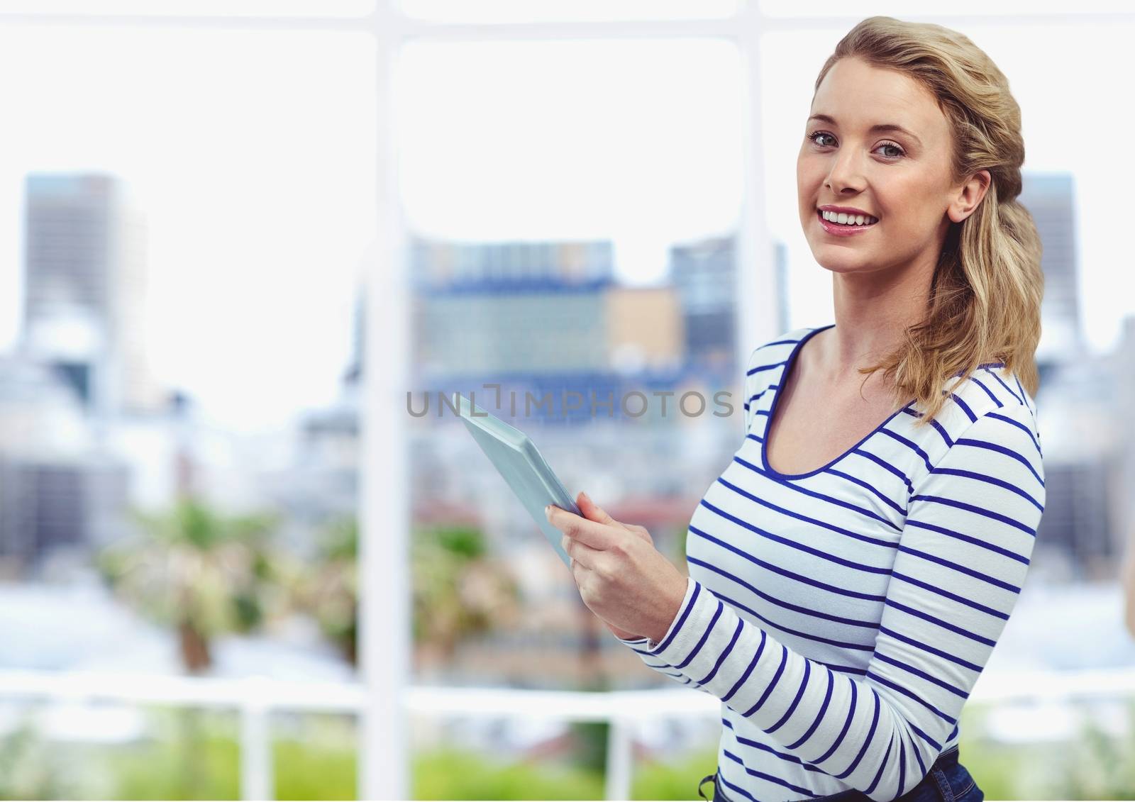 Digital composite of Smiling young woman holding digital tablet outdoors