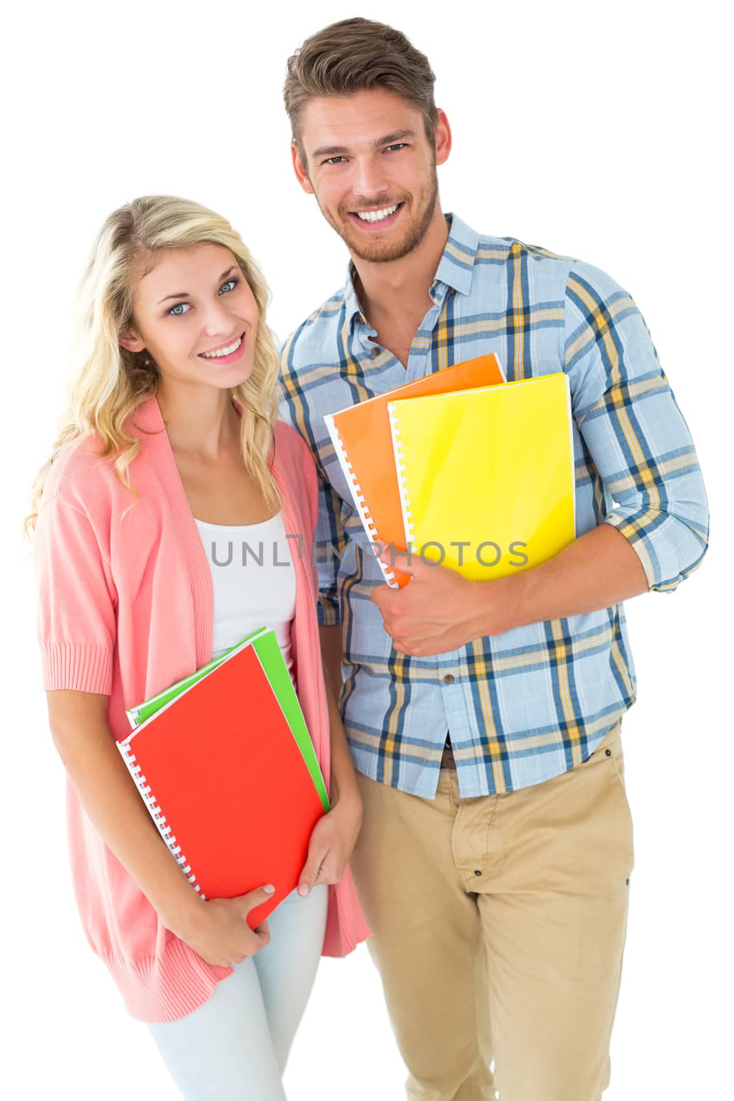 Attractive student couple smiling at camera on white background