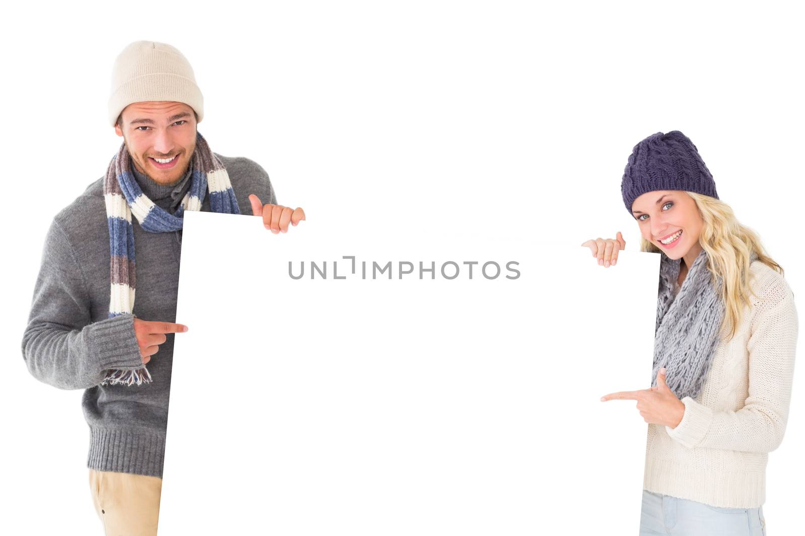 Attractive couple in winter fashion showing poster on white background