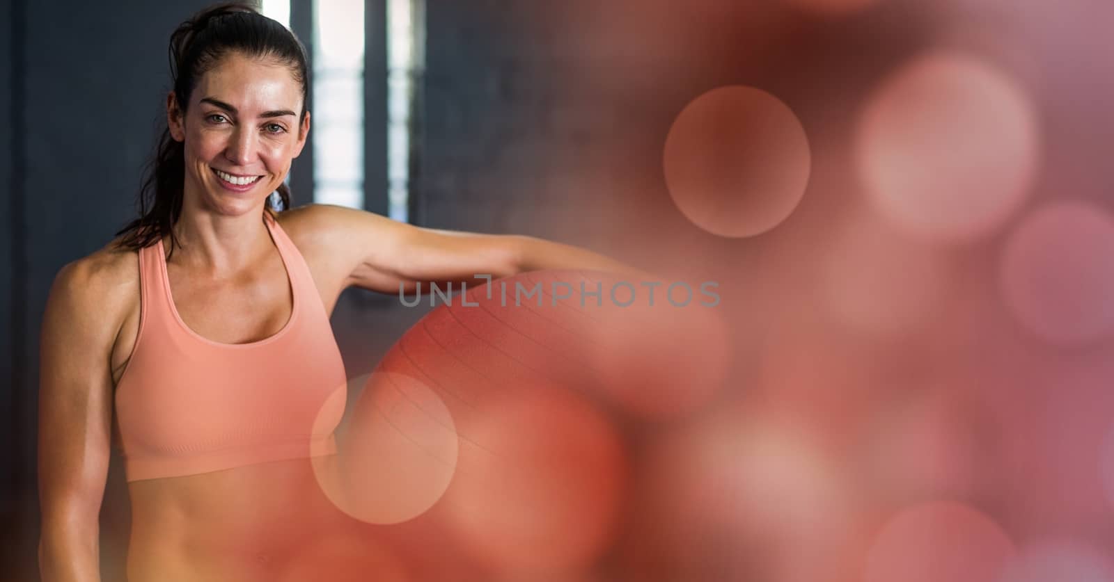 Digital composite of Woman with yoga ball and red bokeh transition
