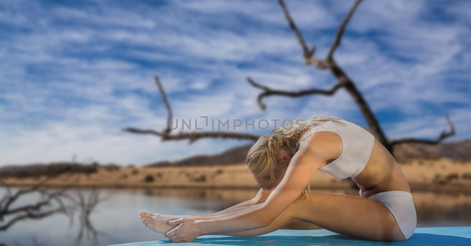 Double exposure of woman performing yoga by lake by Wavebreakmedia