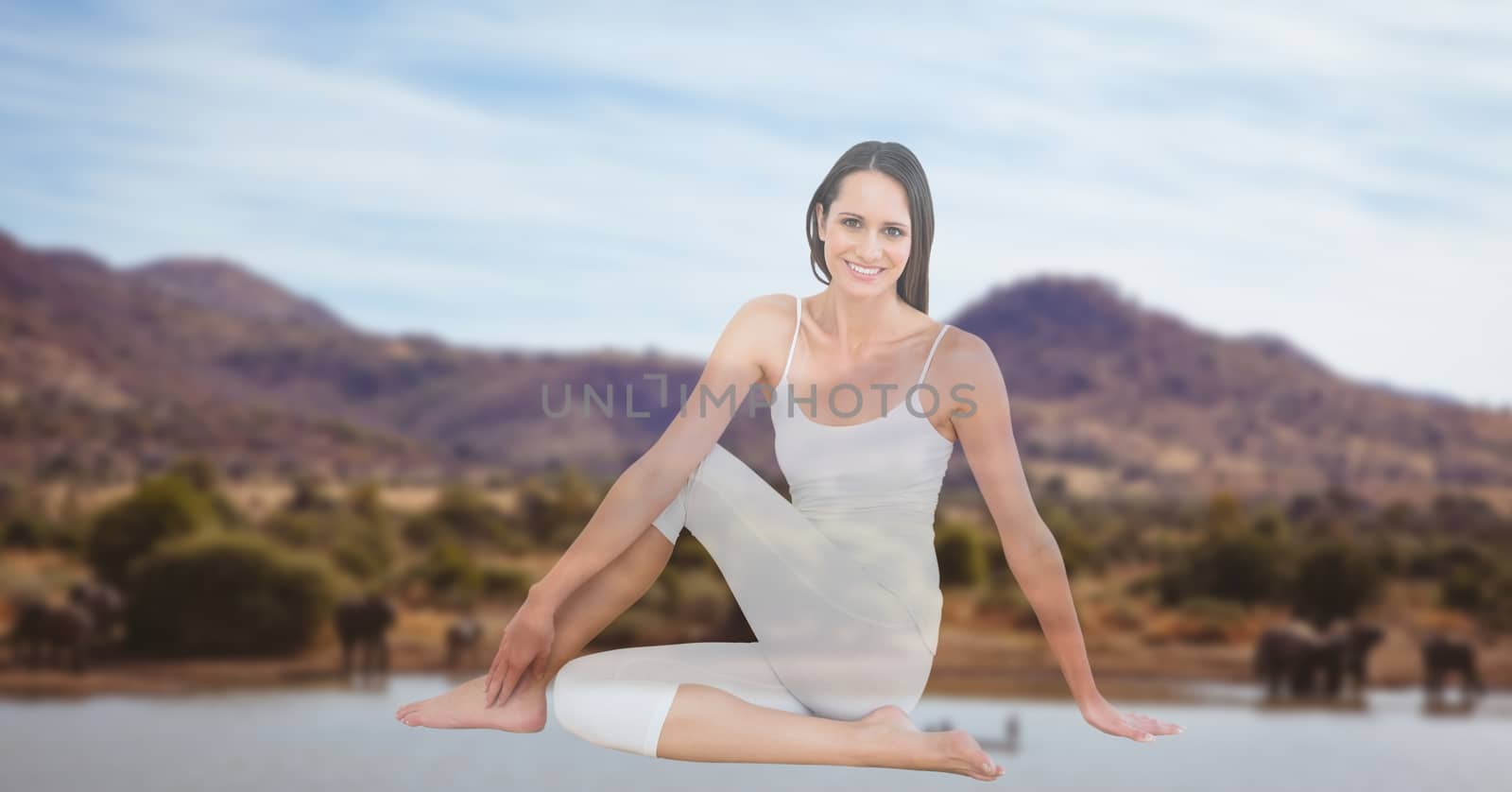 Young woman performing yoga with mountains in background by Wavebreakmedia