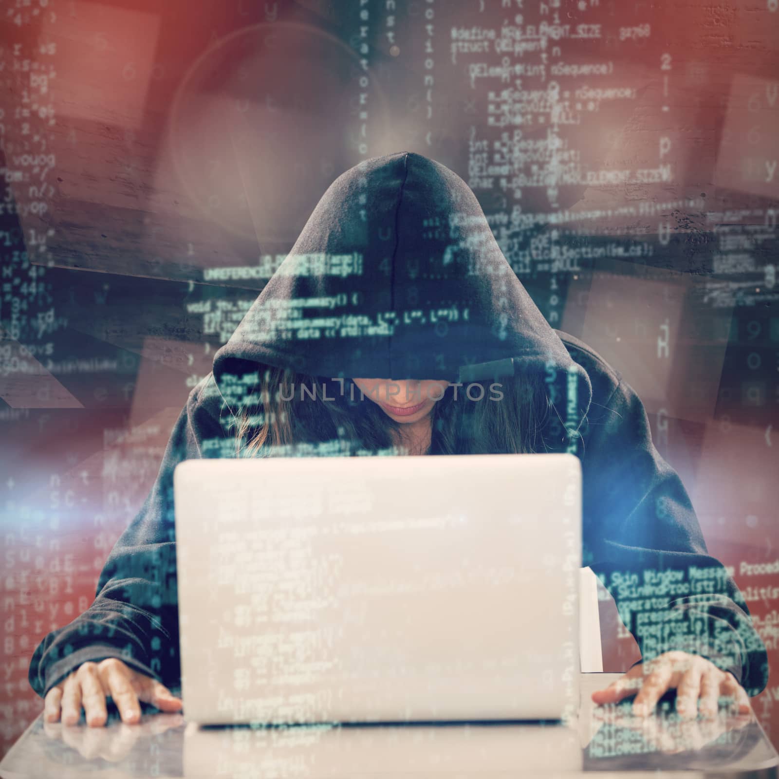 Female hacker sitting by laptop on table  against abstract room
