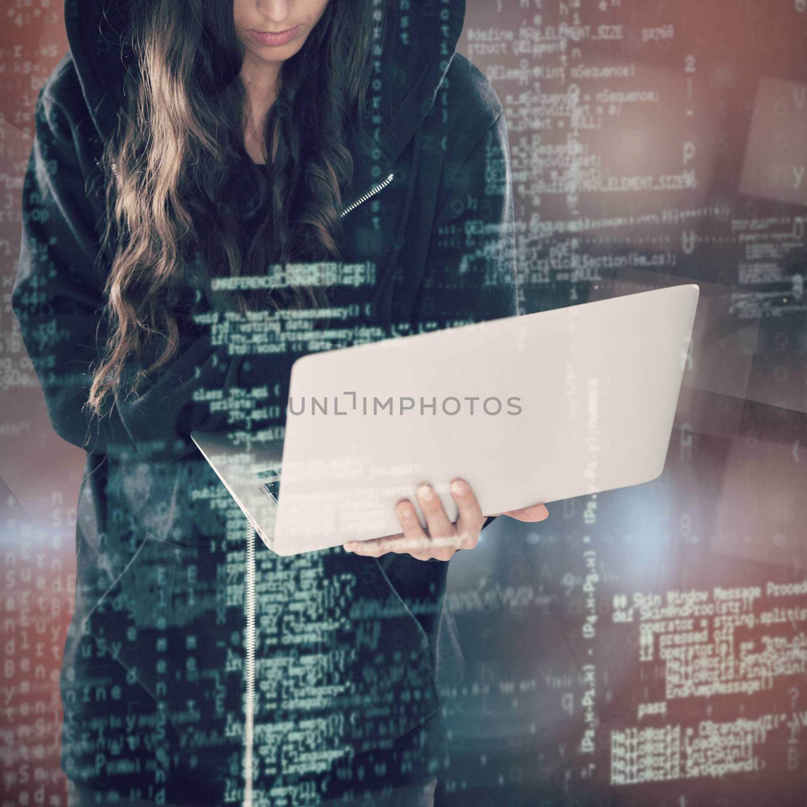Female hacker in black hoodie using laptop against abstract black room
