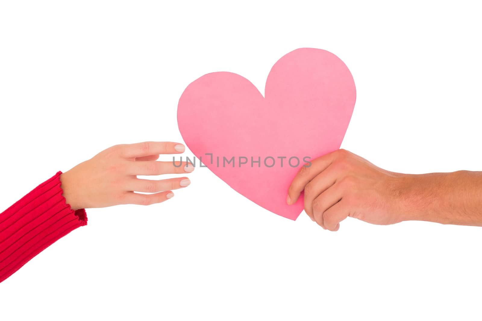 Couple passing a paper heart on white background