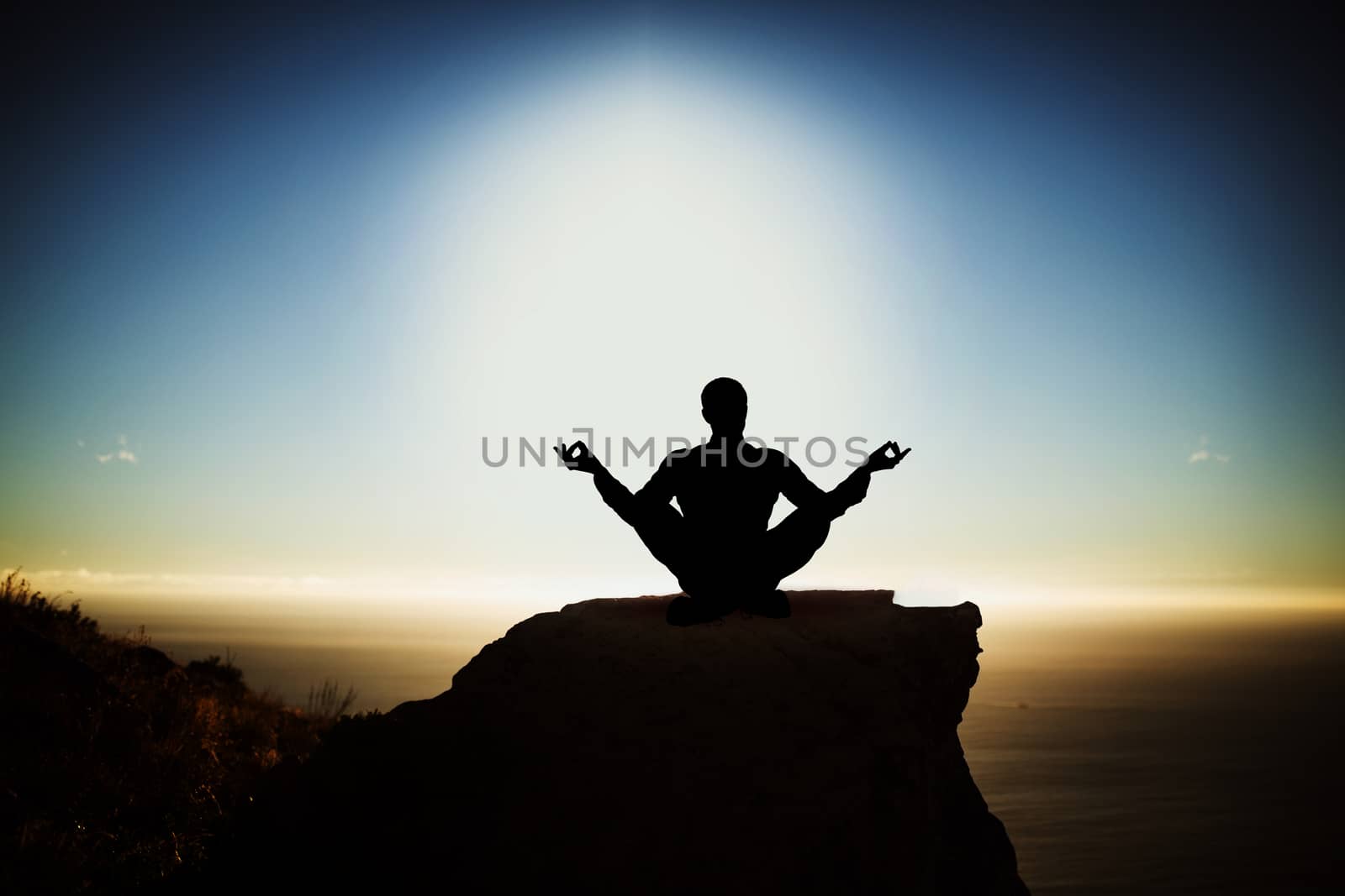 Silhouette businessman practising yoga against scenic view of mountain by sea against sky