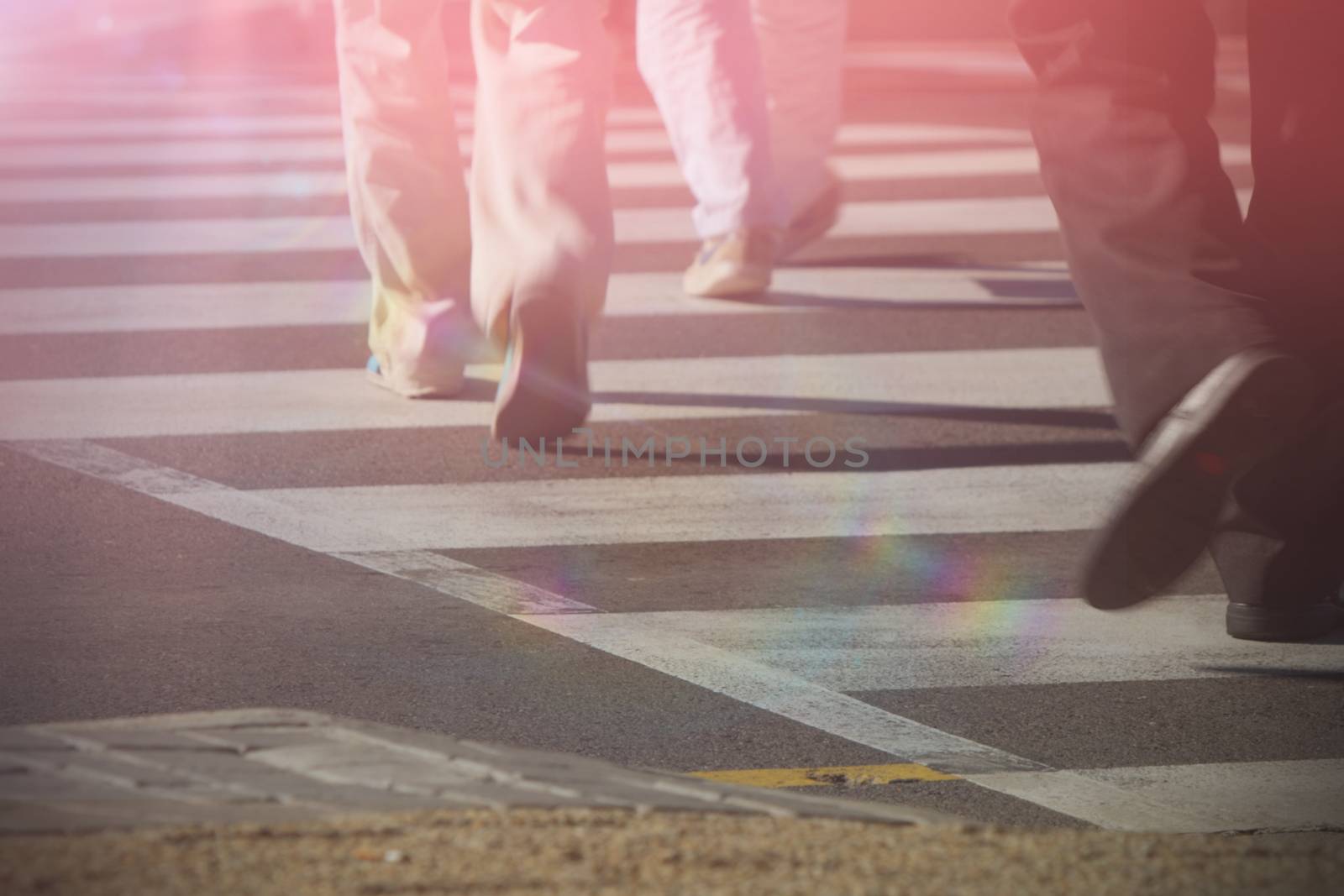 Cropped image of people walking on zebra crossing