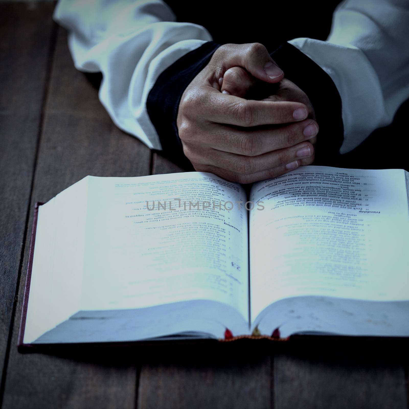 Cropped hands of woman by bible at table