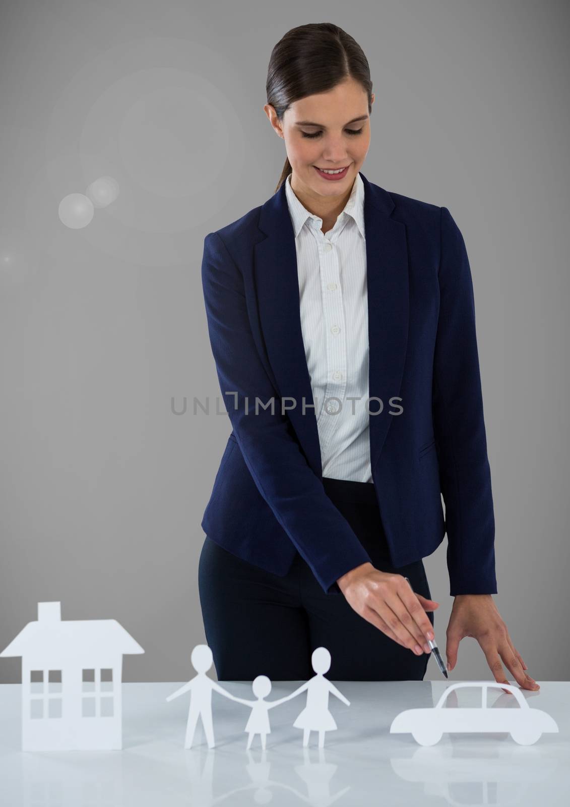 Woman with cut outs of  house family and car insurance by Wavebreakmedia