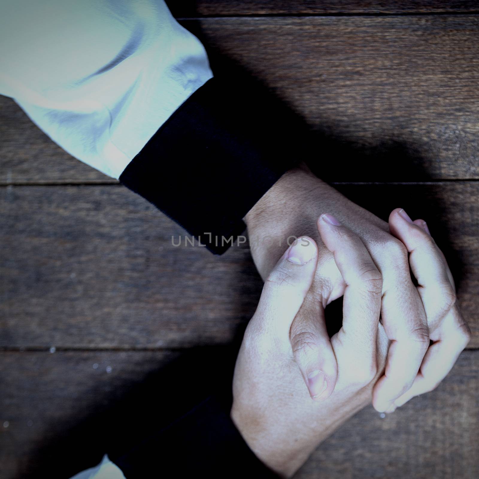 Woman praying on wooden table by Wavebreakmedia