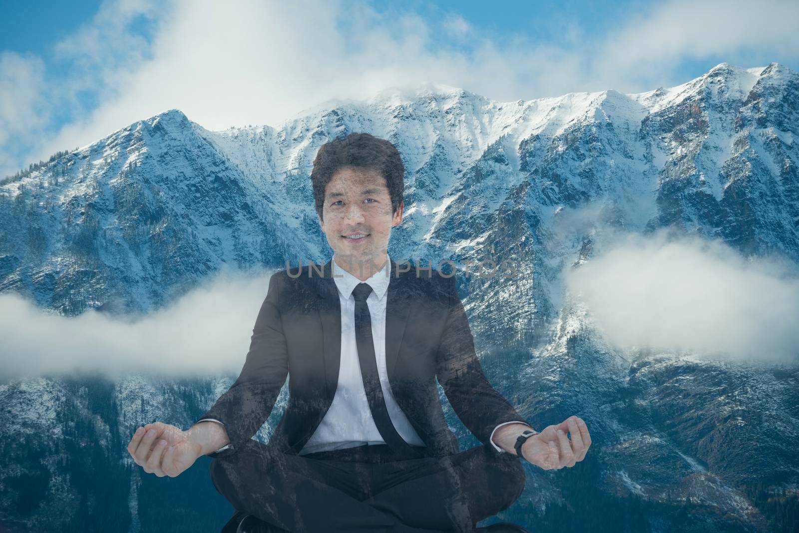 Businessman doing yoga position in front of snow-covered mountains by Wavebreakmedia