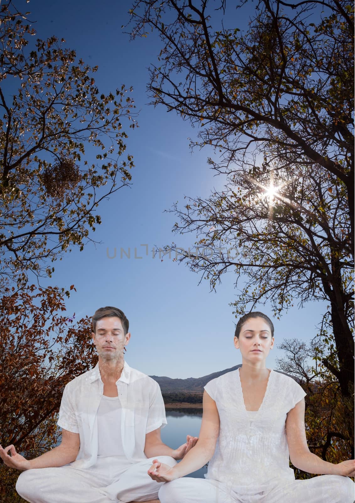 Digital composite of Woman and man doing yoga in front of a lake and mountains