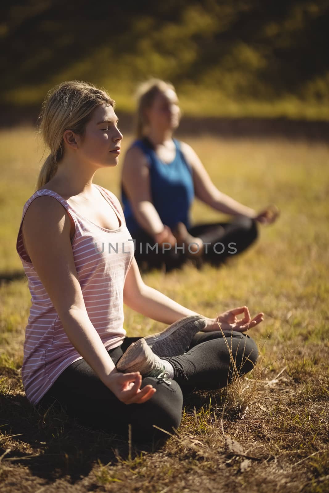 Women practicing yoga during obstacle course in boot camp