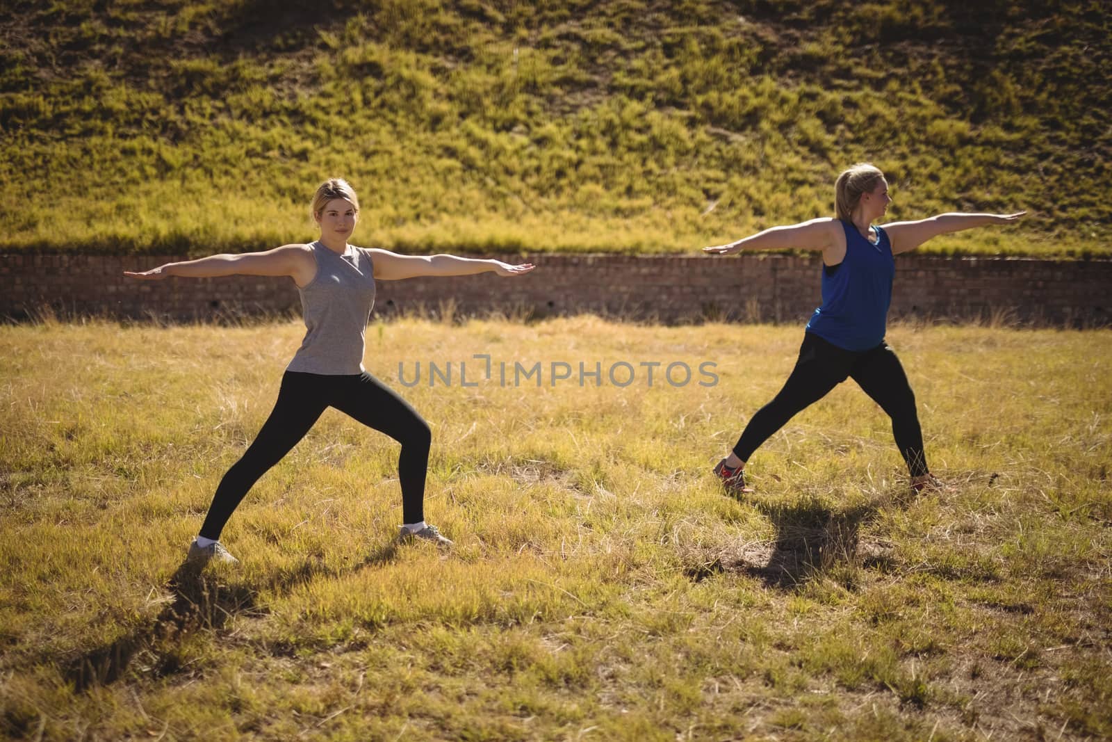Beautiful women praising yoga during obstacle course by Wavebreakmedia