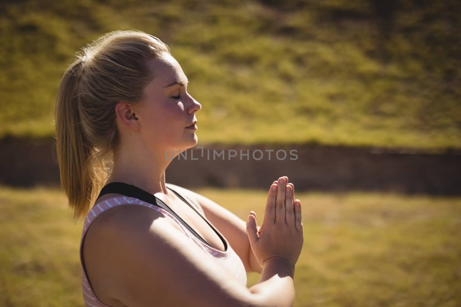 Beautiful woman praising yoga during obstacle course in boot camp
