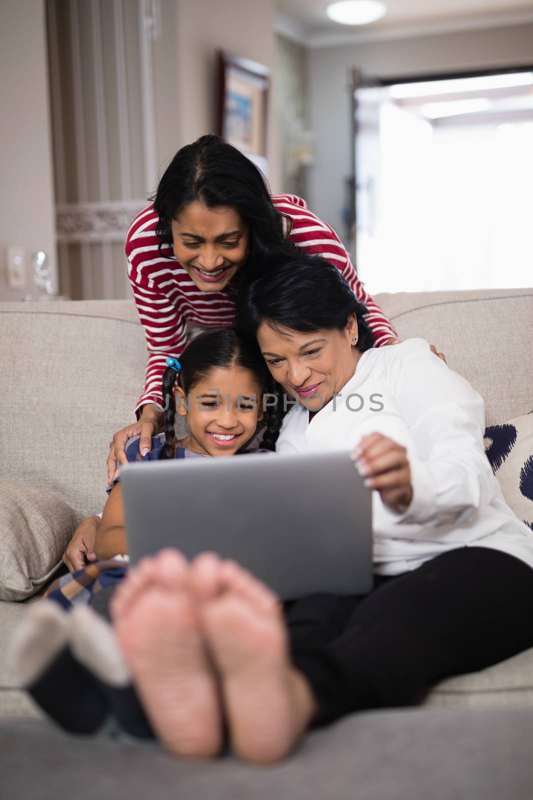 Smiling multi-generation family using laptop together by Wavebreakmedia