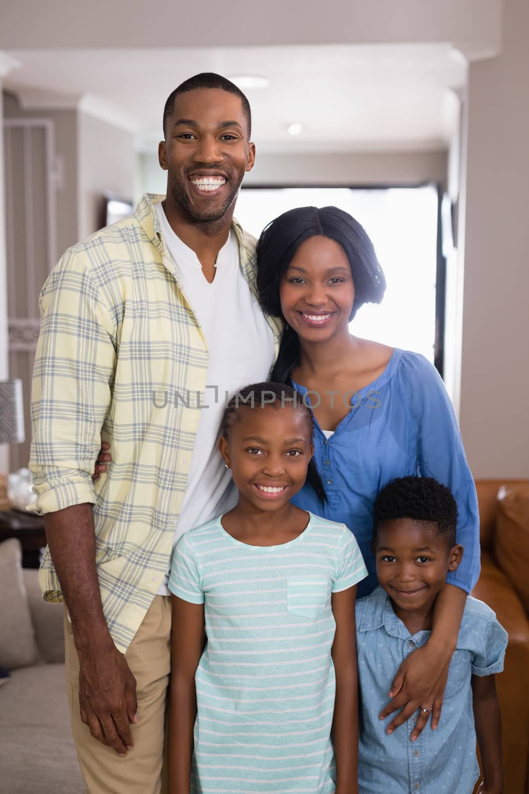 Portrait of smiling family standing in living room at home