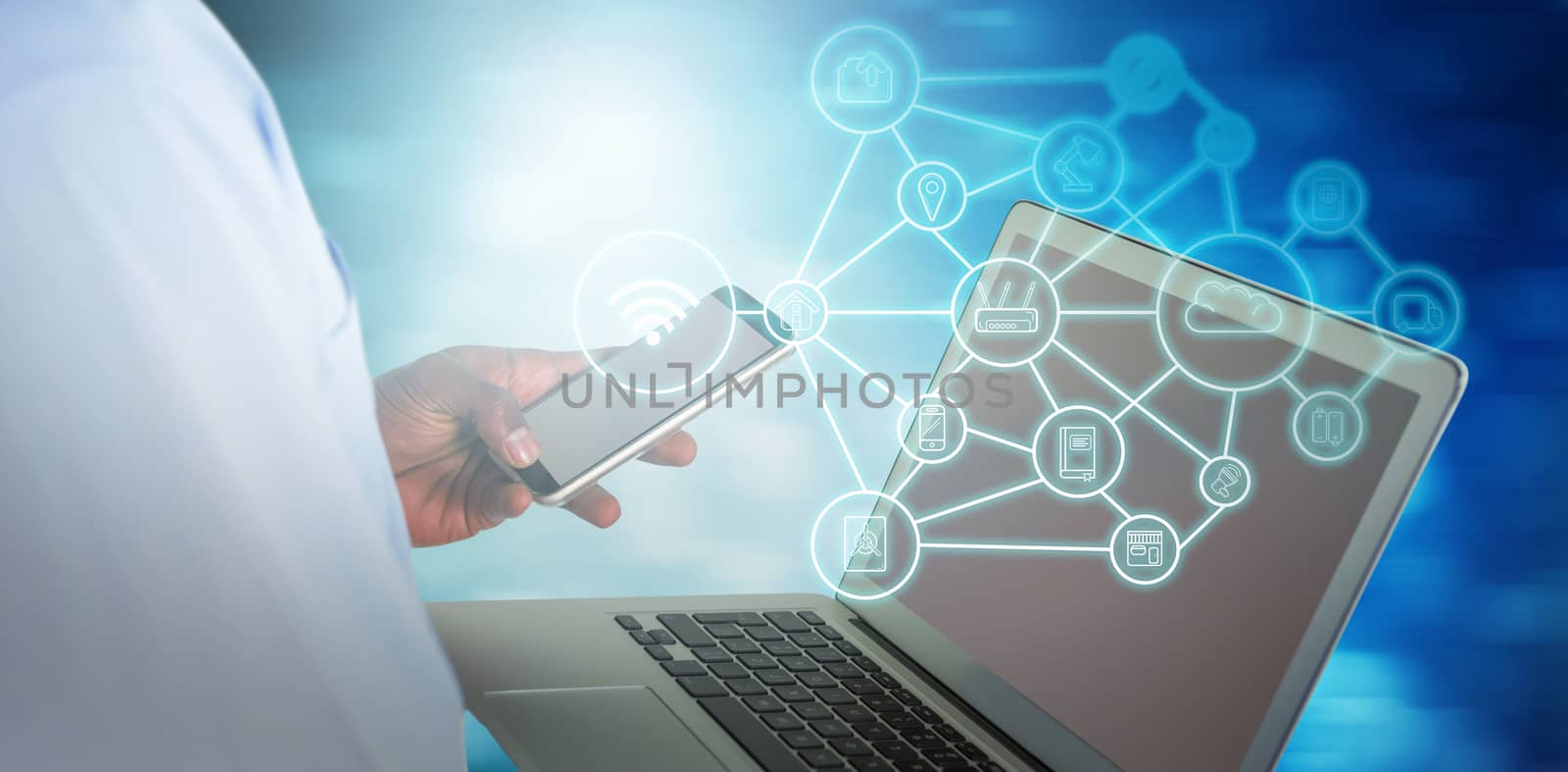 Businessman using mobile phone and laptop against blue abstract light spot design