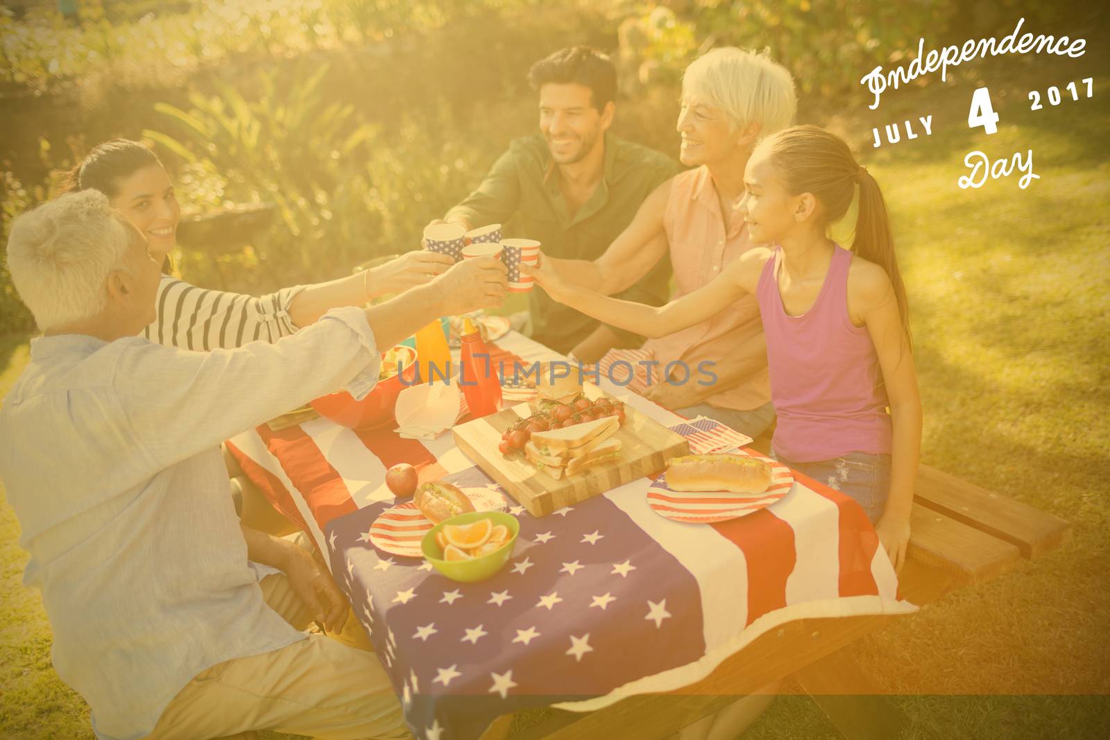 Digitally generated image of happy 4th of july message against happy family having a picnic