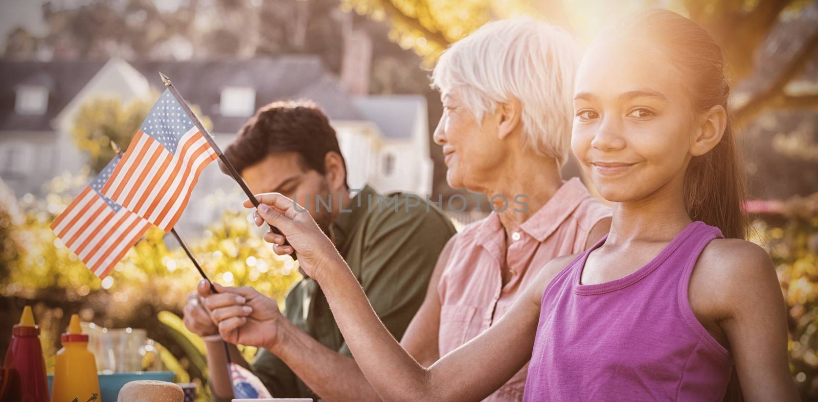 Happy family having a picnic and taking american flag on an american tableclothe