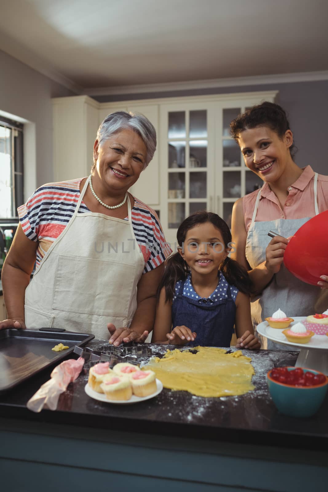 Happy family preparing desserts in kitchen by Wavebreakmedia