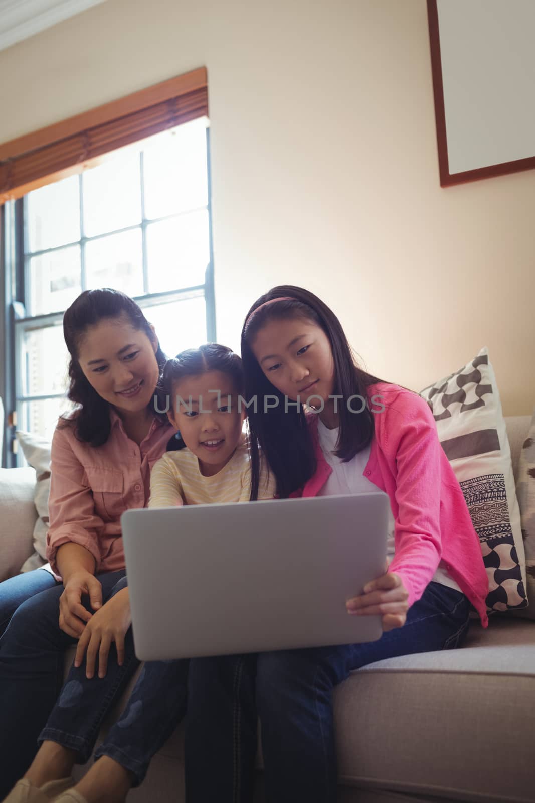 Family using laptop together in living room at home