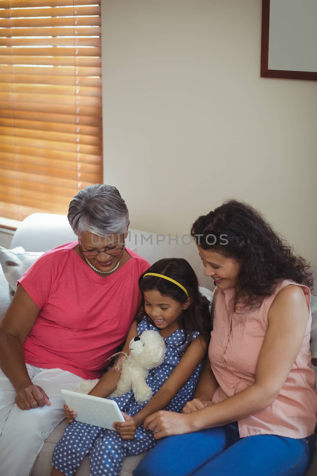 Happy family using digital tablet in living room at home