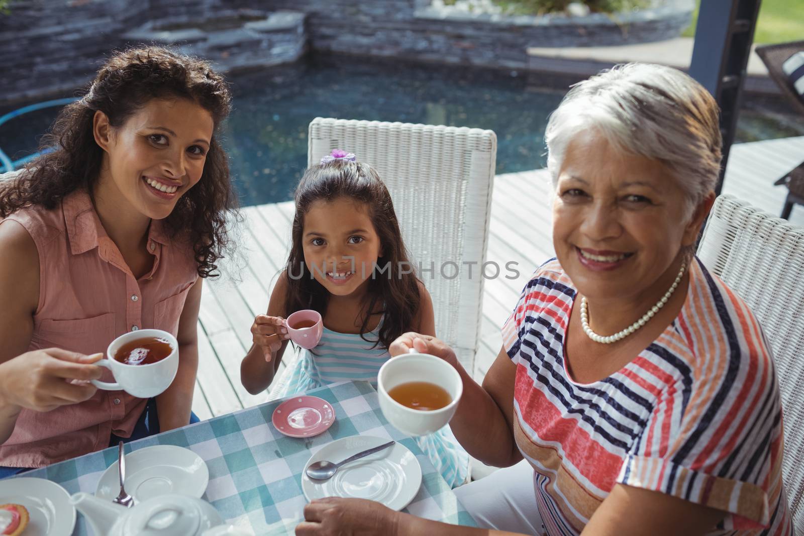 Portrait of happy family having tea at home