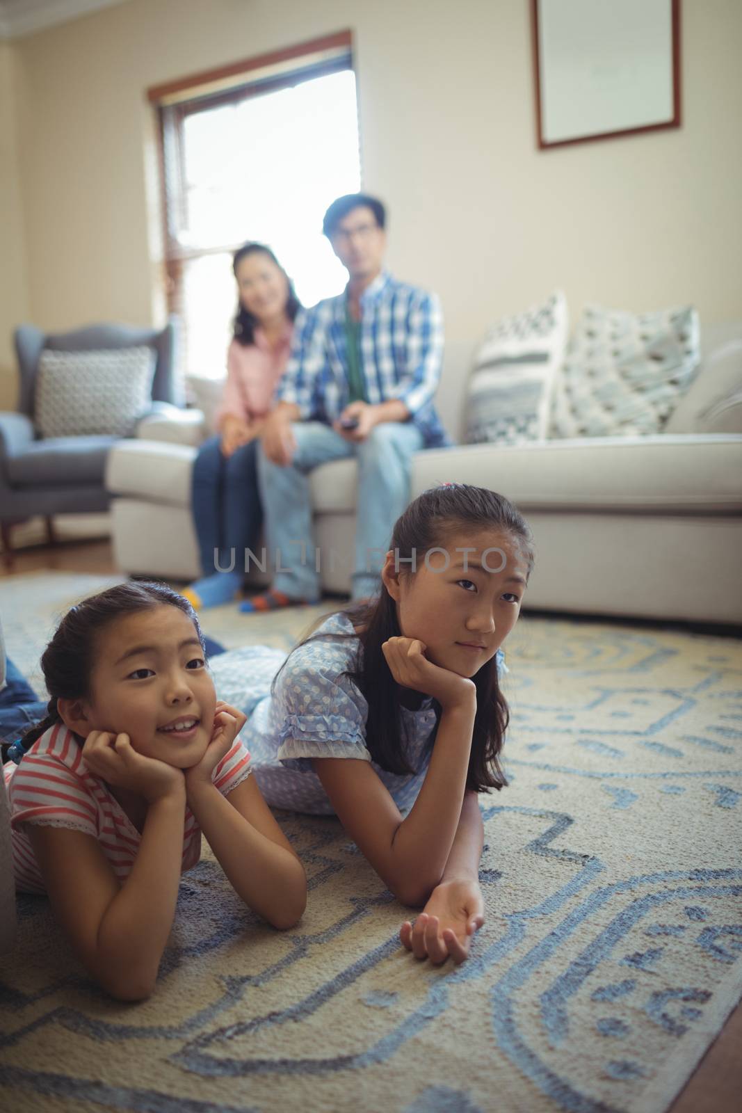 Family watching television together in living room at home