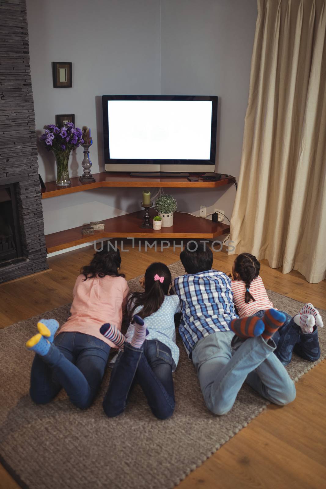 Family watching television together in living room at home