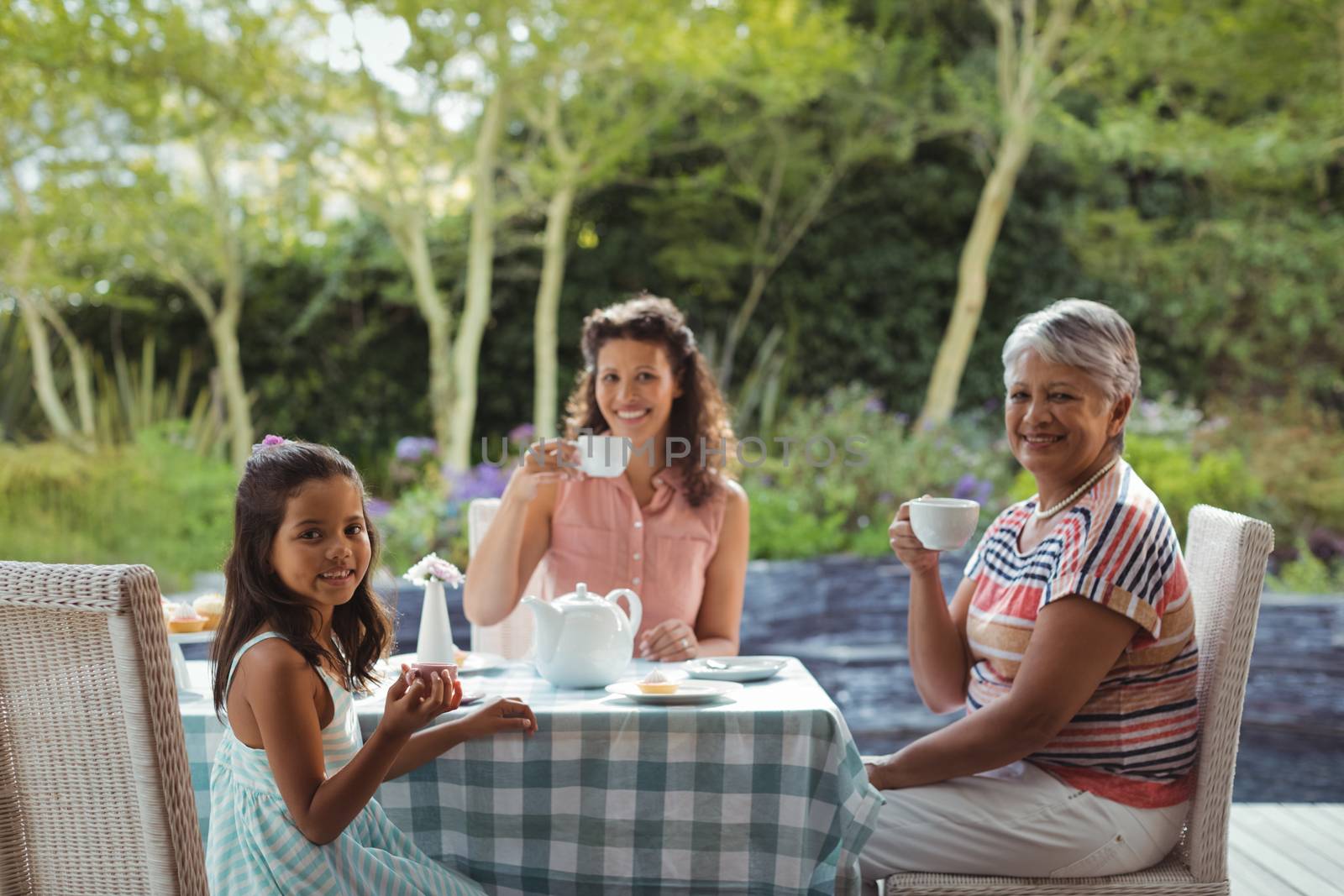 Portrait of happy family having tea at home