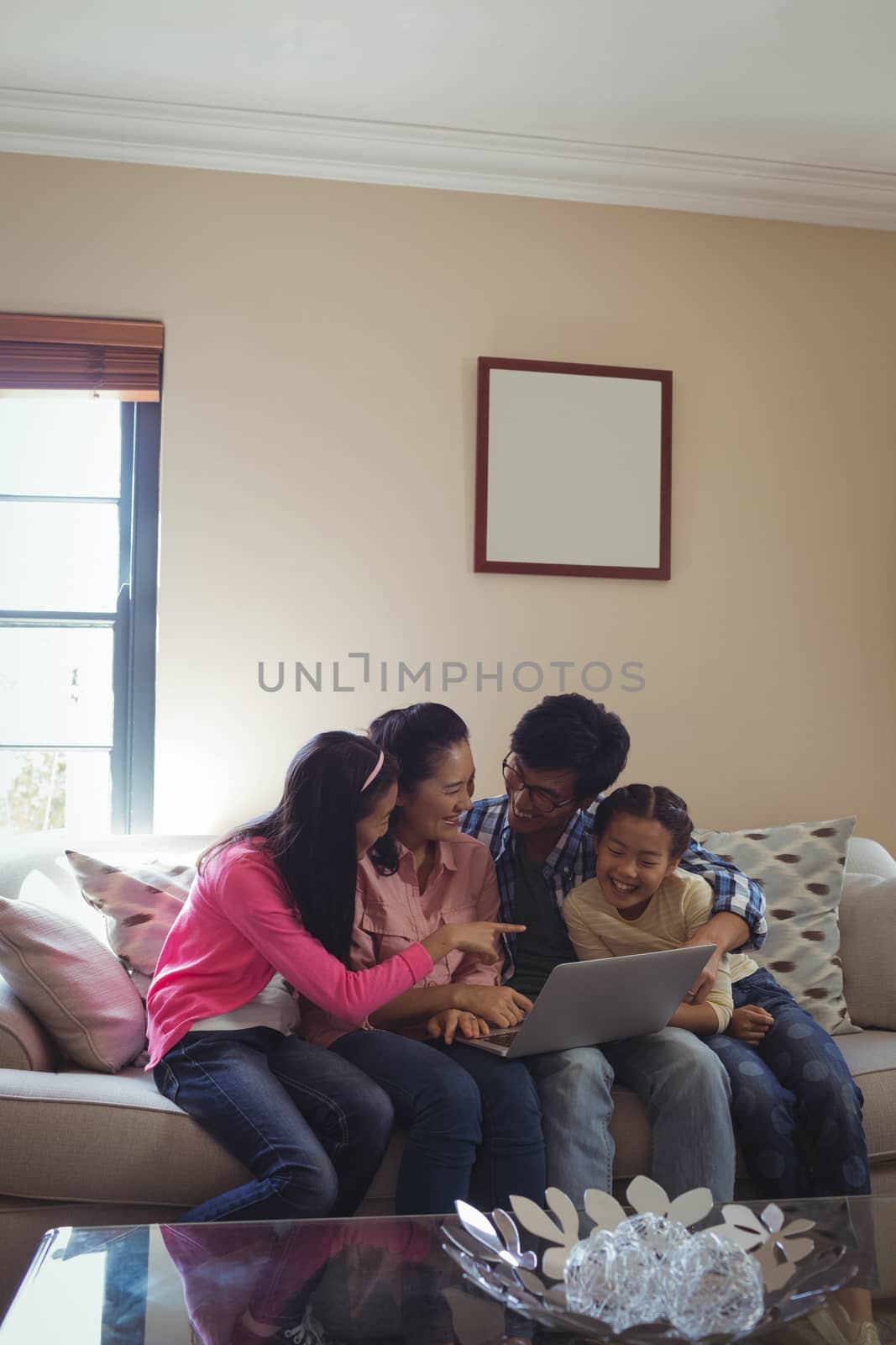 Family using laptop together in living room by Wavebreakmedia