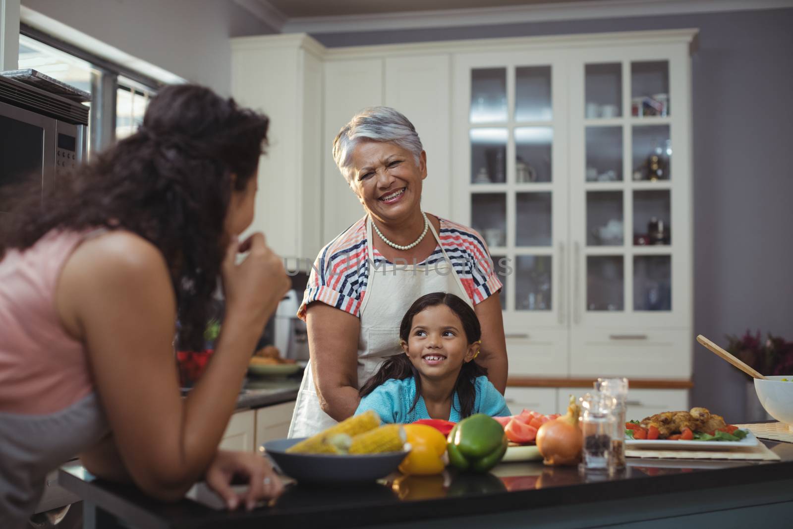 Smiling family interacting with each other in kitchen at home