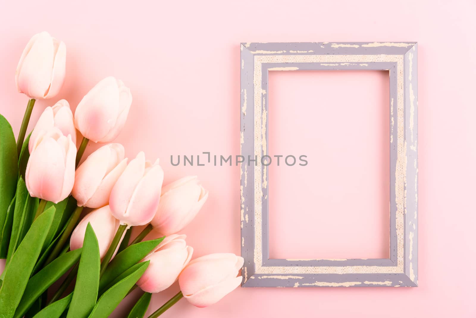 Happy Women's Day, Mother's Day concept. top view flat lay photo frame and Tulip flower on pink background, copy space for your text