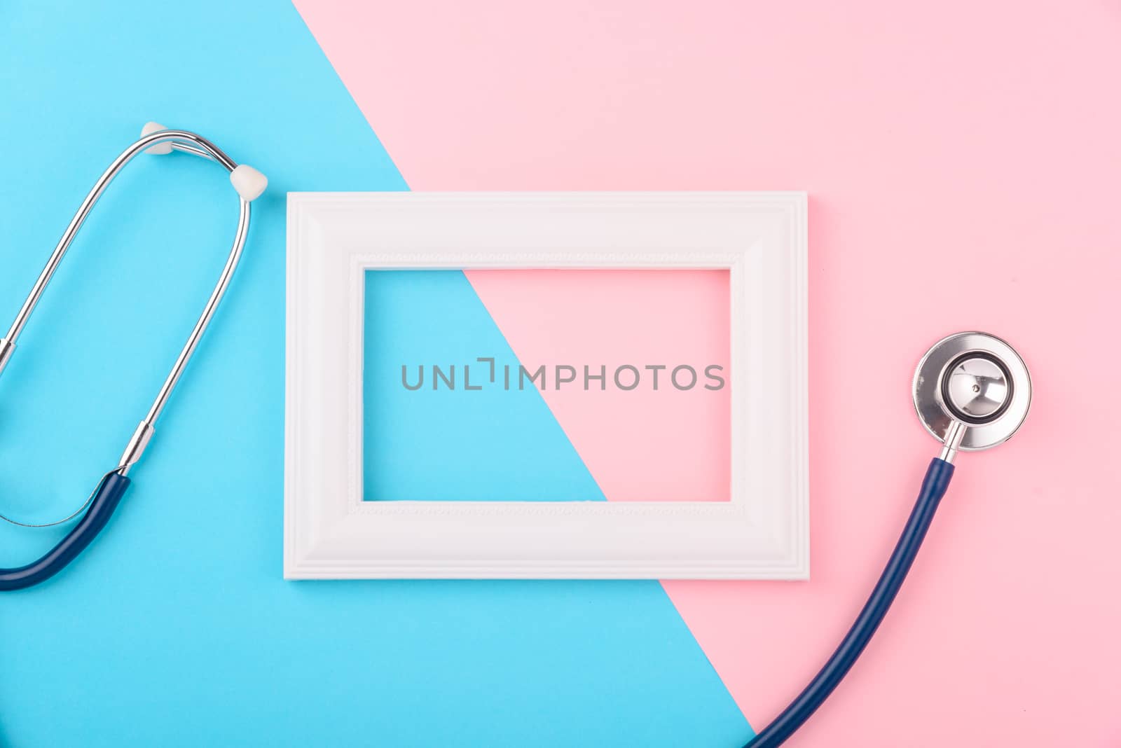 Doctor's Day concept, flat lay top view, stethoscope with photo frame on pink blue background, diagnosis of heart disease with copy space for text