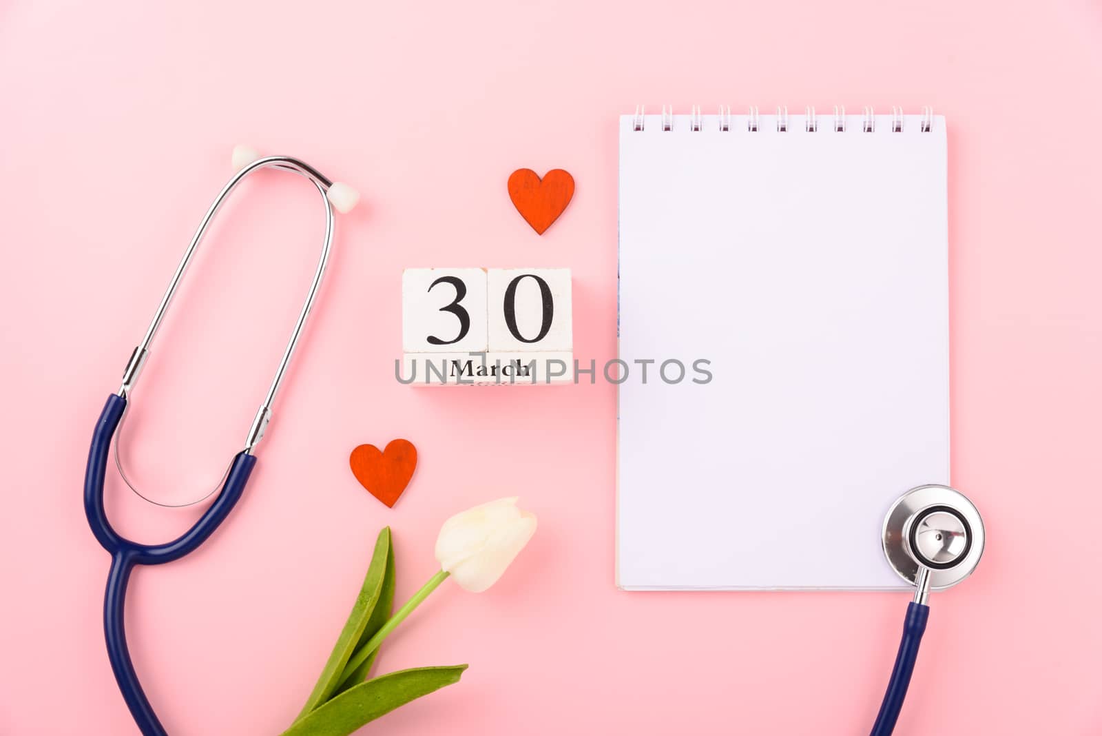 Doctor's Day concept, flat lay top view, equipment medical red heart stethoscope and note book on pink background, care patient in hospital with copy space for text