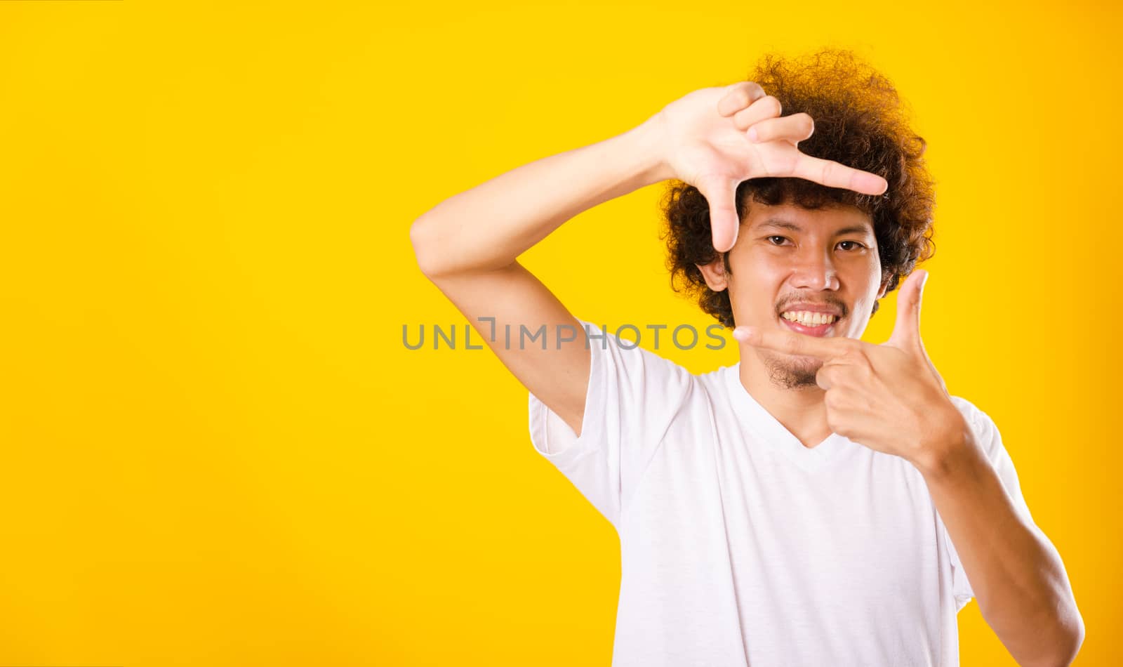 Asian handsome man with curly hair he smiling making frame with  by Sorapop