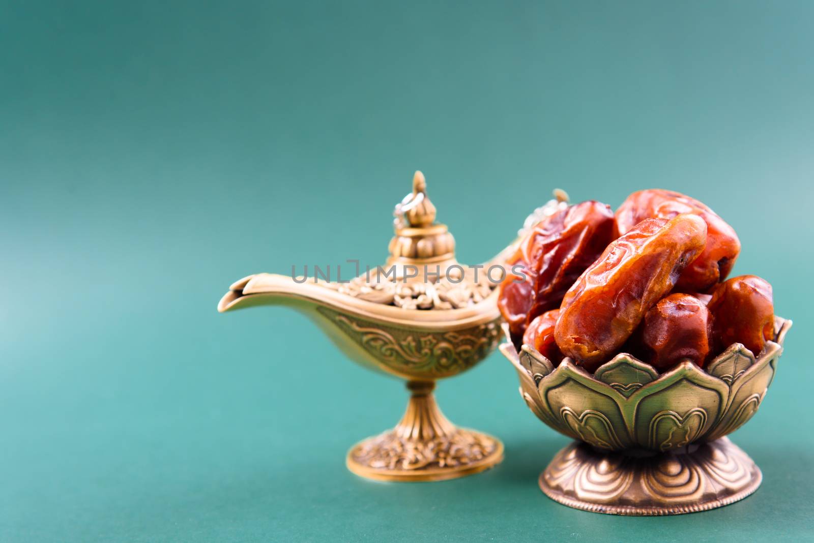 Ramadan, Dates in golden bowl, arabian Aladdin golden lamp vintage style on black green background
