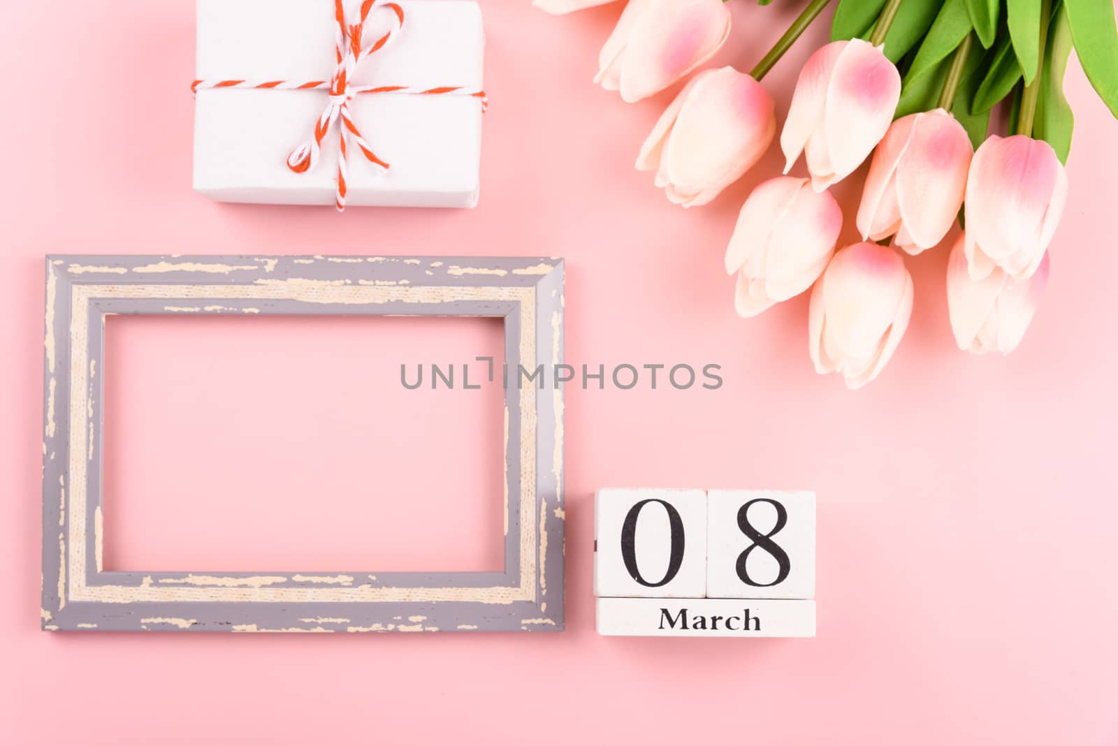 Happy Women's Day, Mother's Day concept. top view flat lay Tulip flower and photo frame on pink background, copy space for your text
