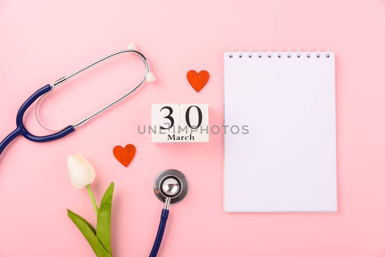 Doctor's Day concept, flat lay top view, equipment medical red heart stethoscope and note book on pink background, care patient in hospital with copy space for text
