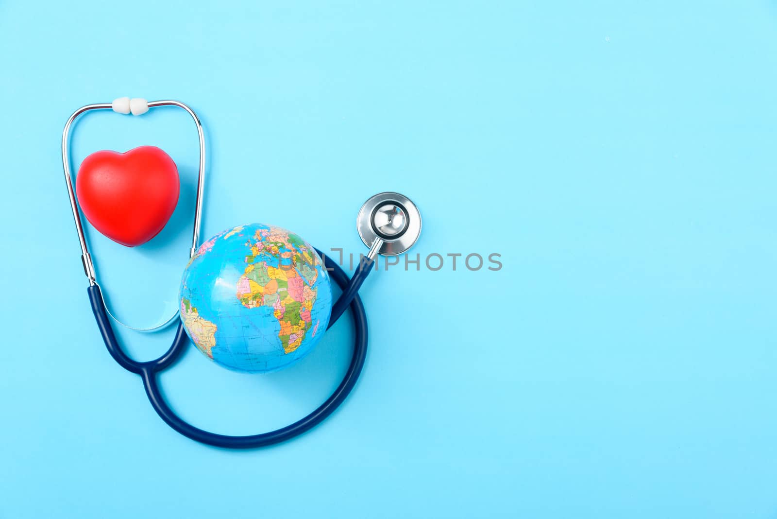 World health day concept, Stethoscope, globe and red heart on blue background with copy space. Global health care